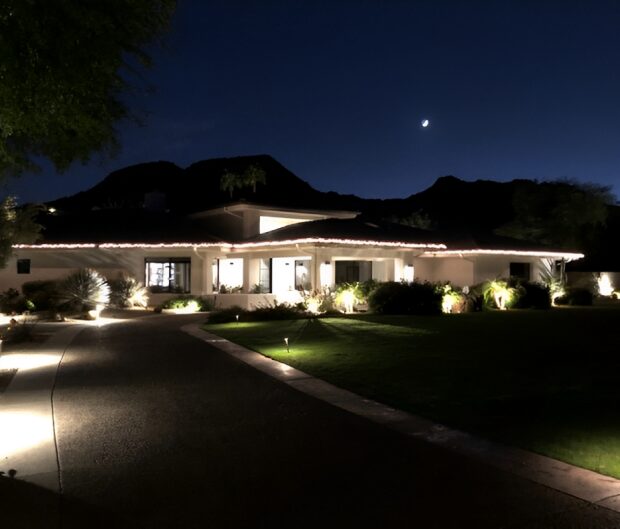 House with lights on under night sky.